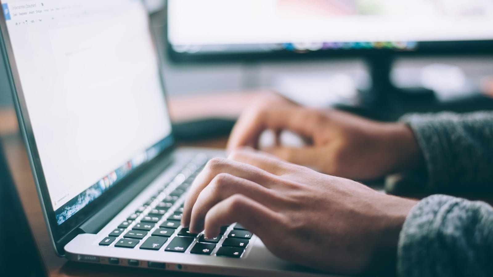 Mãos sobre teclado de computador em fotografia ilustrativa de consulta