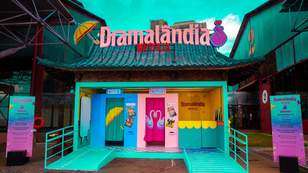 Estação Dramalândia Netflix com telhado em estilo coreano, rampas e painéis coloridos com guarda-chuva amarelo