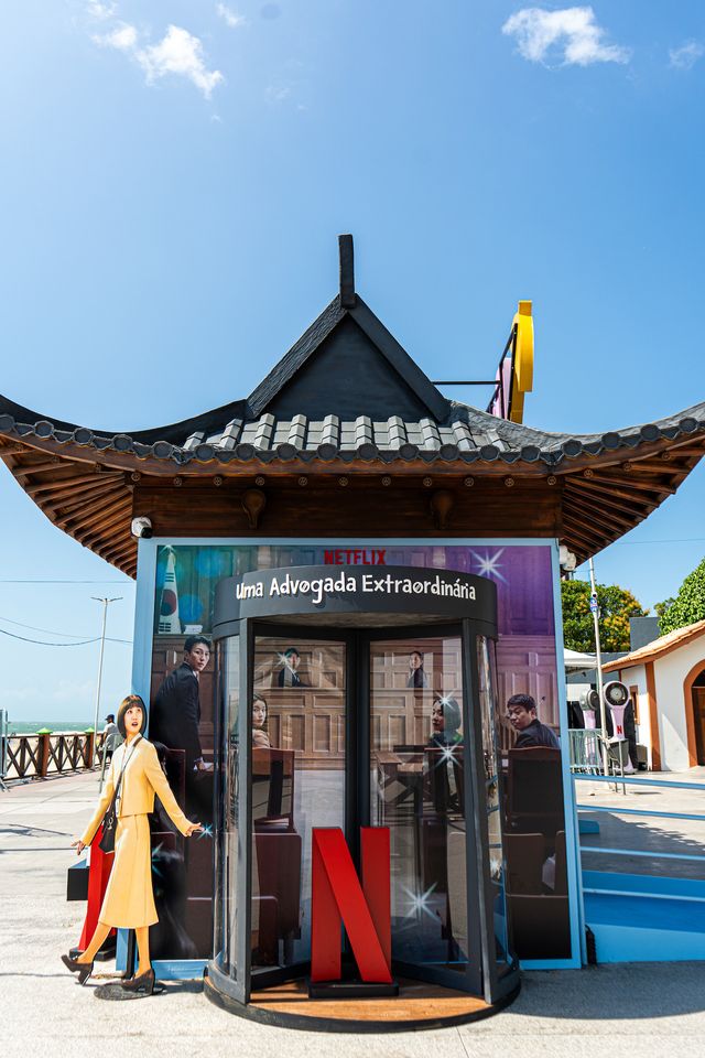 Estação da campanha com porta giratória, painel de Uma Advogada Extraordinária e boneco em tamanho real de uma personagem de terninho