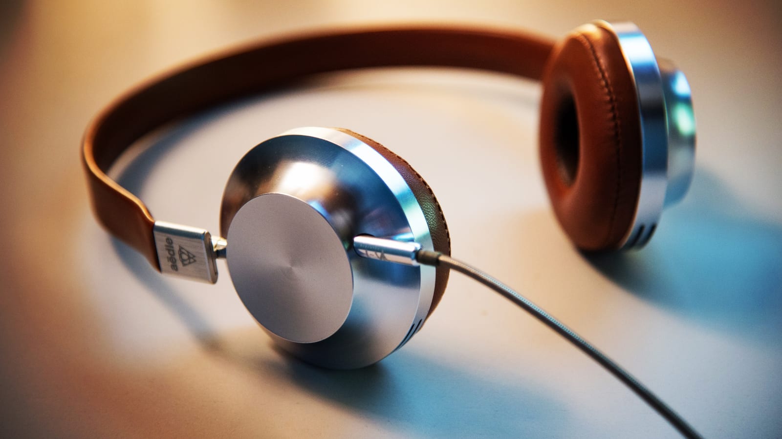 Fones de ouvido com acabamento marrom sobre uma mesa