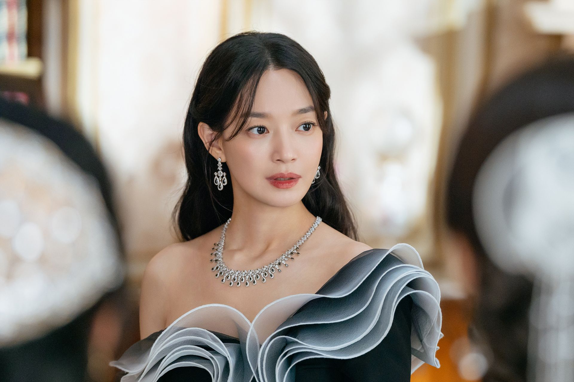 Shin Min-a como Navier, com vestido de babados claros e colar em ambiente de palácio