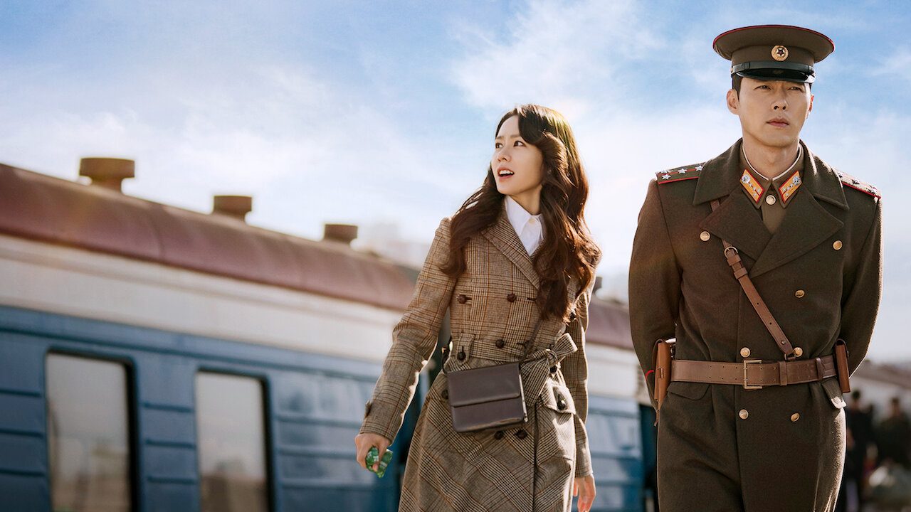 Yoon Se-ri e Ri Jeong-hyeok junto a um trem em imagem oficial de Pousando no Amor