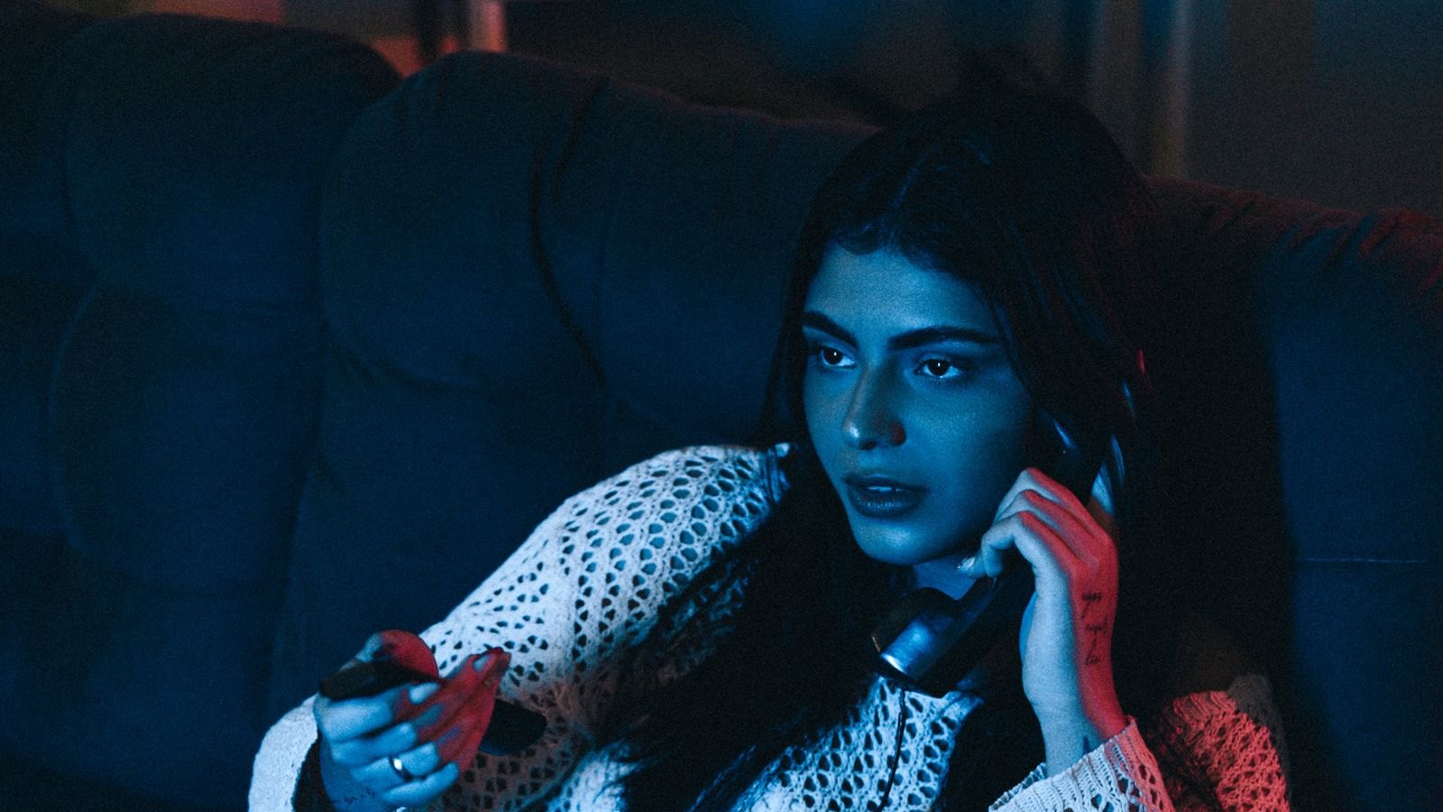 Mulher assiste a uma televisão em casa