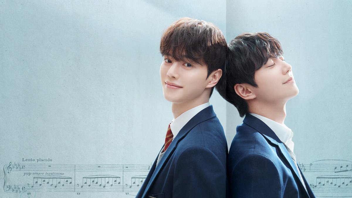 Song Kang e Lee Jun-young de uniforme escolar encostados costas com costas diante de uma partitura